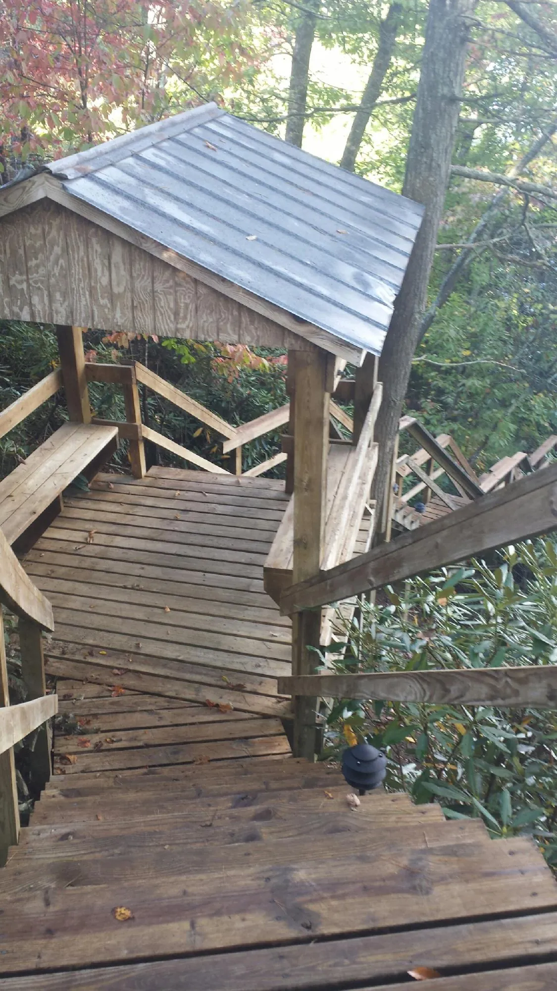 Metal roofed shelter over wooden steps on a wooded walkway — Skylight Repair & Installation work by our crew in Johnson